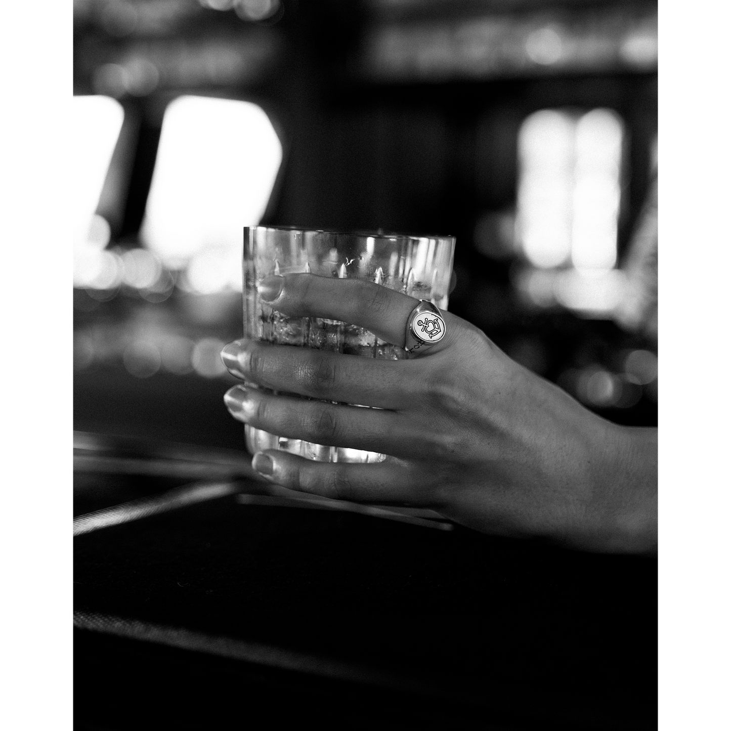 Hand holding a glass and wearing the Hold Fast Ring