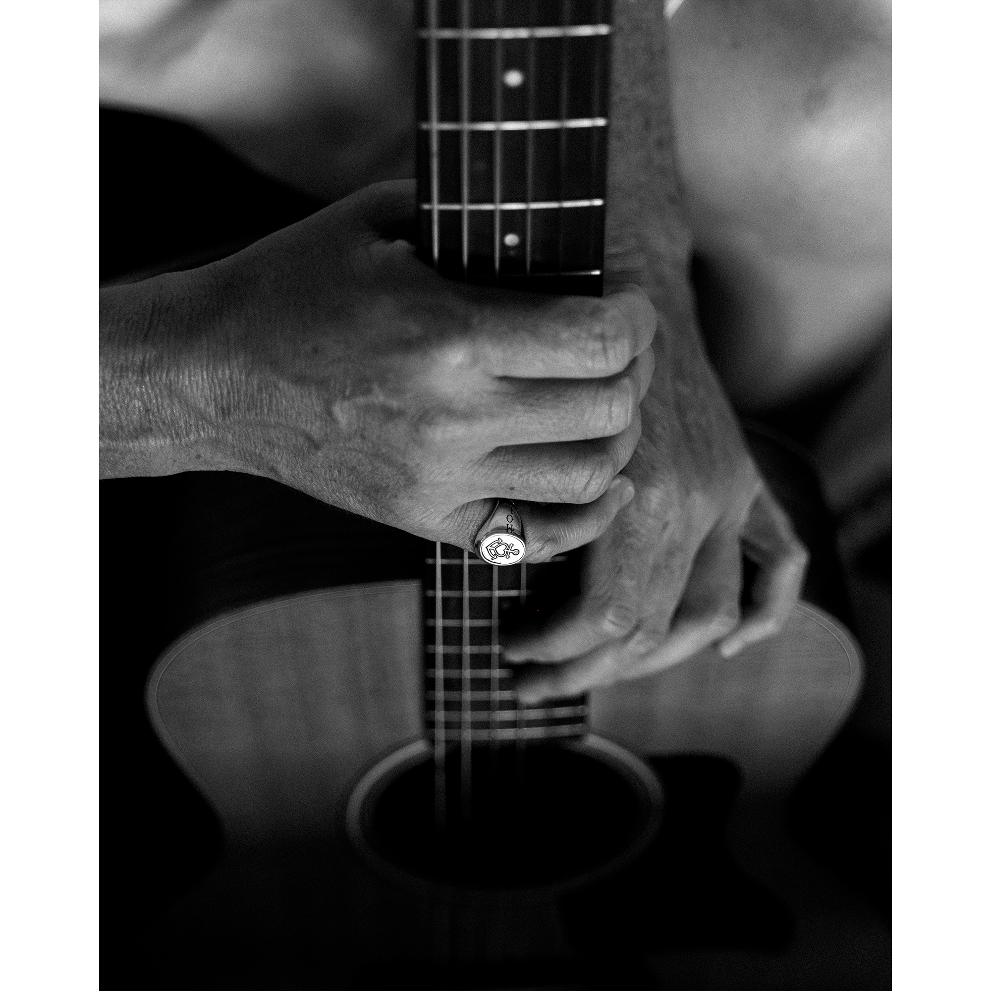 Person holding guitar wearing the Hold Fast ring 